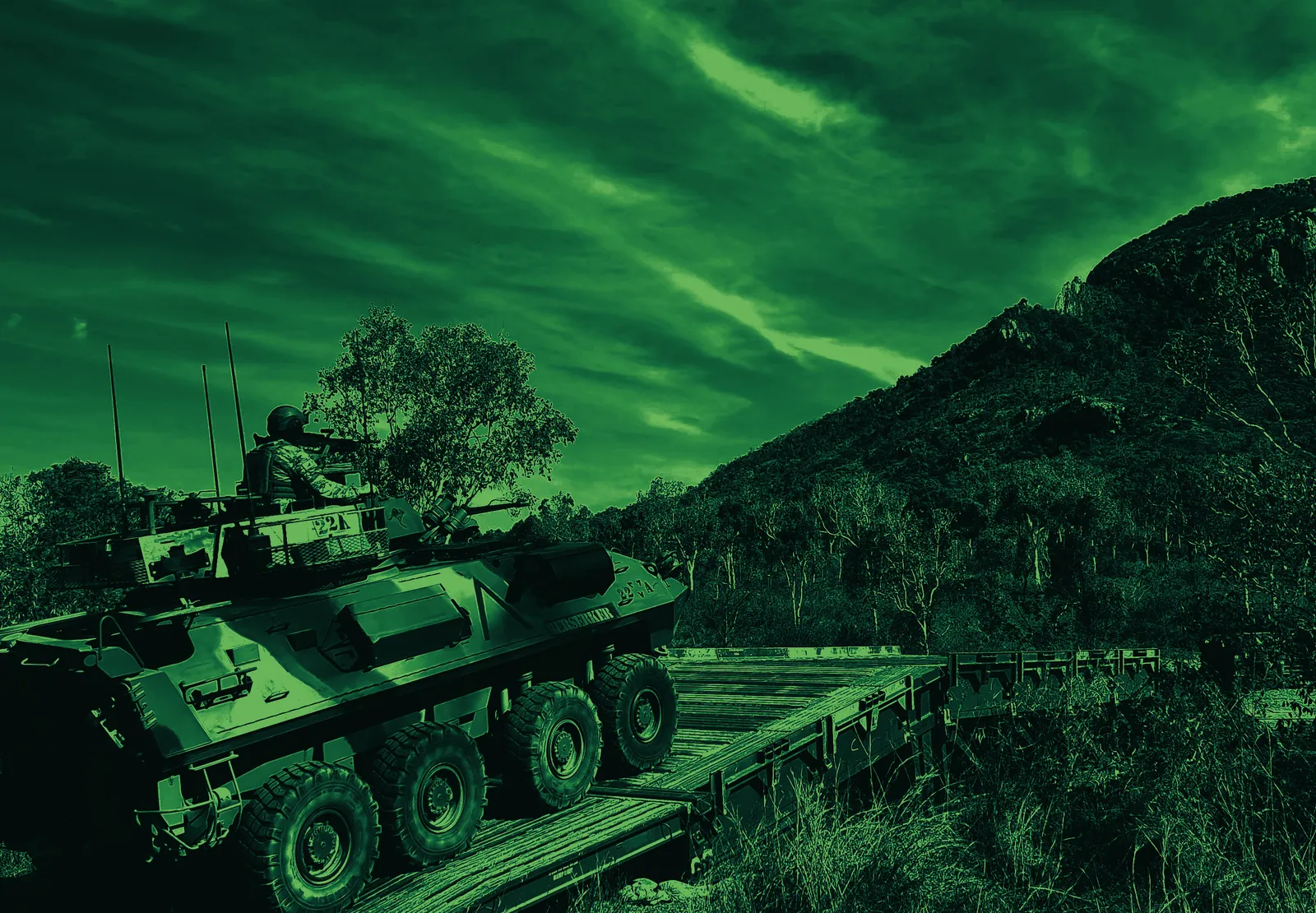 An armoured vehicle on a ridgeline in green-toned light